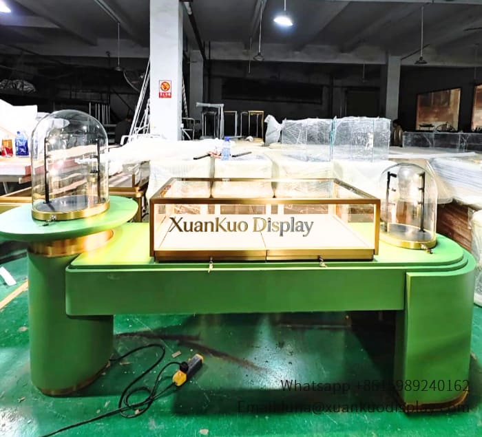watch display table for boutique shop, featuring gold trim, tempered LED glass case and storage drawers to exhibit luxury watches and fine jewelry.